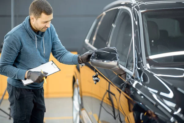 Hail No Dent repair technician preparing to collect information about the hail damage on the car