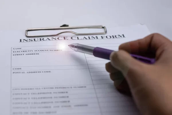 image of a form, with a mans hand resting on the insurance paper work.