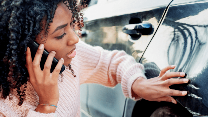 woman inspecting car dent for hail damage